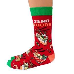 Pair of red men's crew socks with green accents, featuring a noodle bowl design and the phrase 'Send Noods,' decorated with chopsticks and noodle imagery.