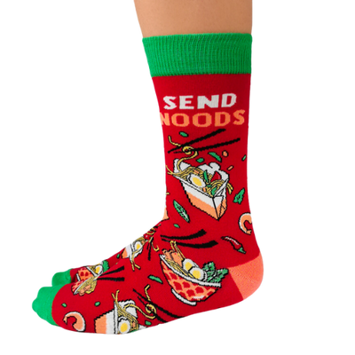 Pair of red men's crew socks with green accents, featuring a noodle bowl design and the phrase 'Send Noods,' decorated with chopsticks and noodle imagery.